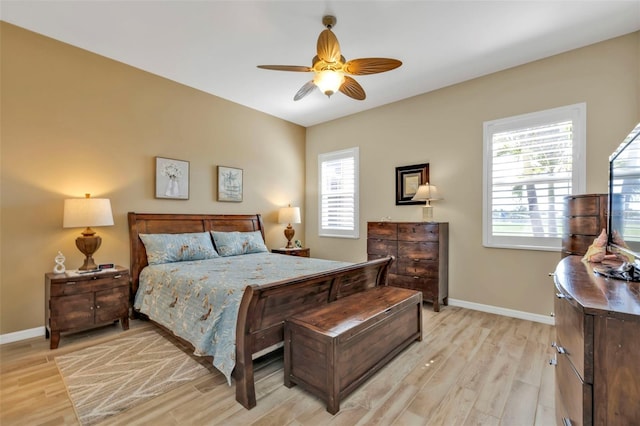 bedroom featuring multiple windows, light hardwood / wood-style floors, and ceiling fan