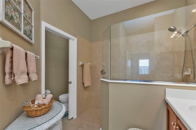 bathroom featuring tiled shower, vanity, toilet, and tile patterned floors