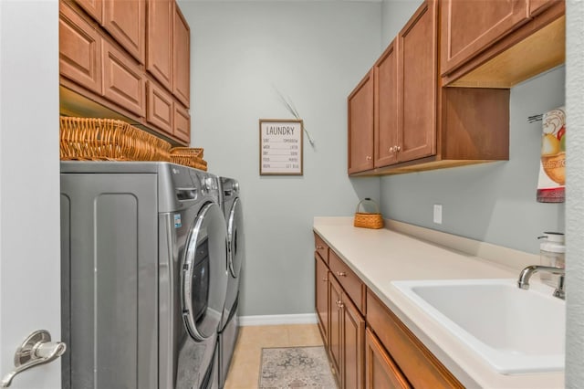 laundry room with cabinets, light tile patterned flooring, sink, and independent washer and dryer