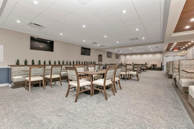 dining area featuring a paneled ceiling, ornamental molding, and light carpet