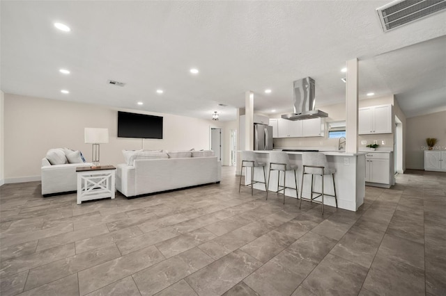 living room featuring sink and a textured ceiling