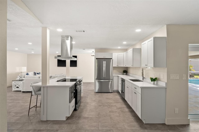 kitchen featuring sink, white cabinetry, stainless steel appliances, a kitchen breakfast bar, and island range hood