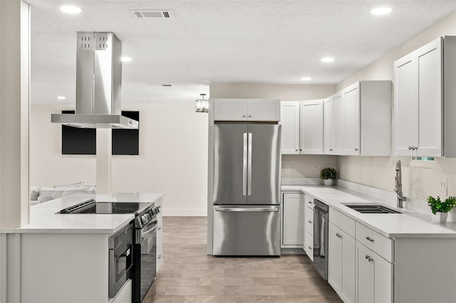 kitchen with island range hood, sink, white cabinets, stainless steel appliances, and a textured ceiling