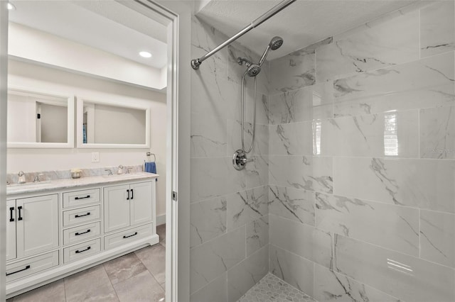 bathroom with vanity and a tile shower