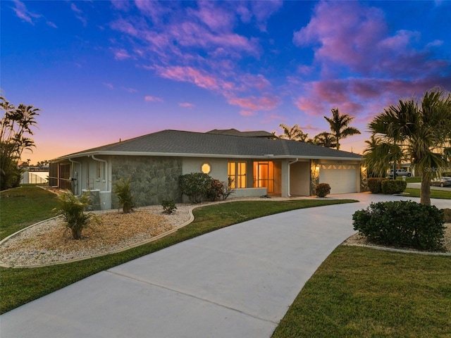 ranch-style home with a garage and a yard