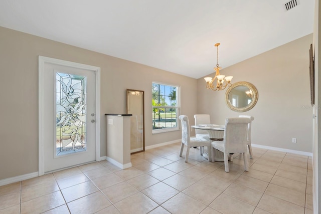 tiled dining room featuring lofted ceiling and an inviting chandelier