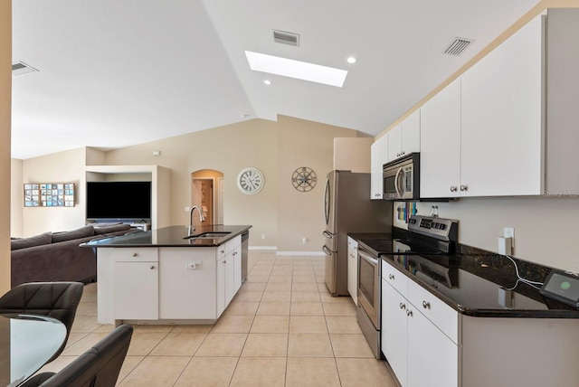 kitchen featuring vaulted ceiling, sink, white cabinets, light tile patterned floors, and stainless steel appliances