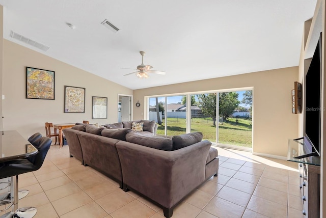 living room featuring lofted ceiling, ceiling fan, and light tile patterned flooring