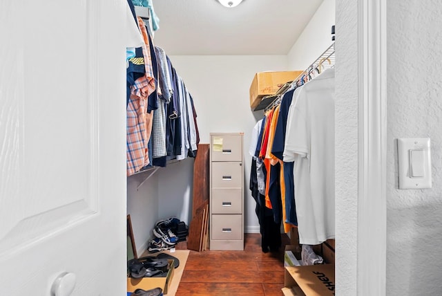 walk in closet with dark hardwood / wood-style flooring