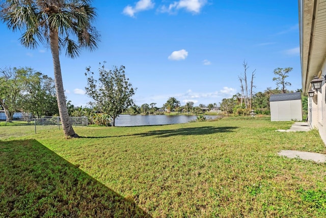 view of yard with a storage unit and a water view