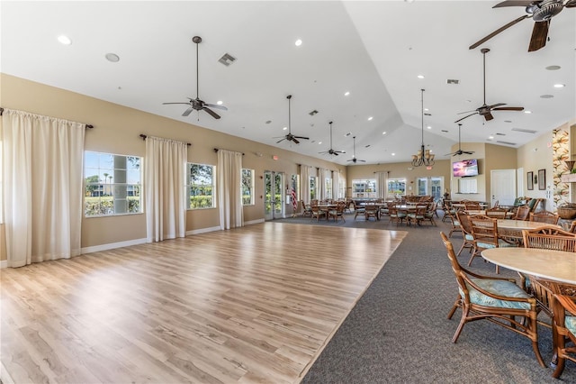 dining space with high vaulted ceiling and light wood-type flooring