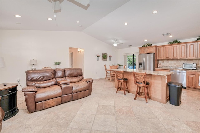 living room with ceiling fan and vaulted ceiling