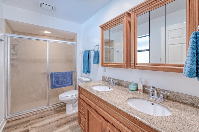 bathroom with vanity, a shower with shower door, toilet, and wood-type flooring