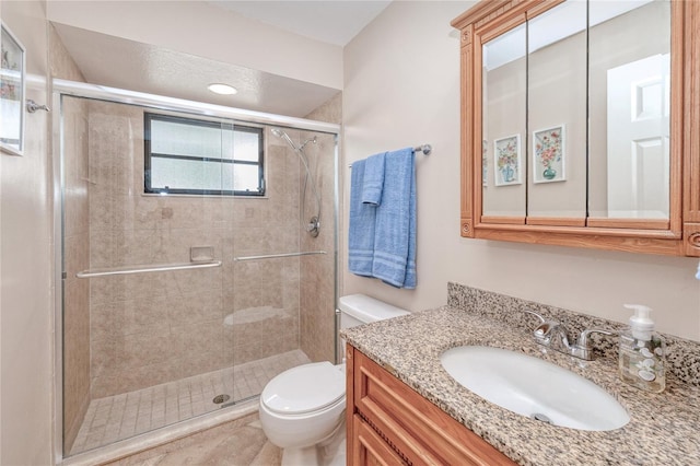 bathroom featuring vanity, an enclosed shower, and toilet