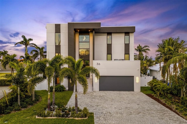 contemporary home with a garage and a lawn