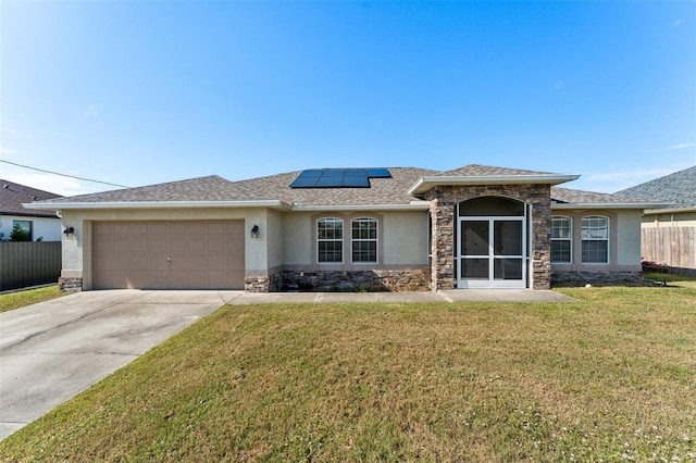 view of front facade with a garage, a front yard, and solar panels