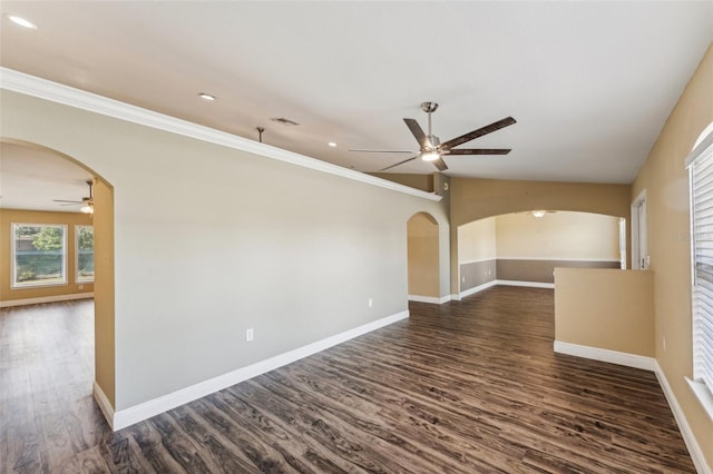 empty room with dark wood-type flooring, ceiling fan, ornamental molding, and lofted ceiling