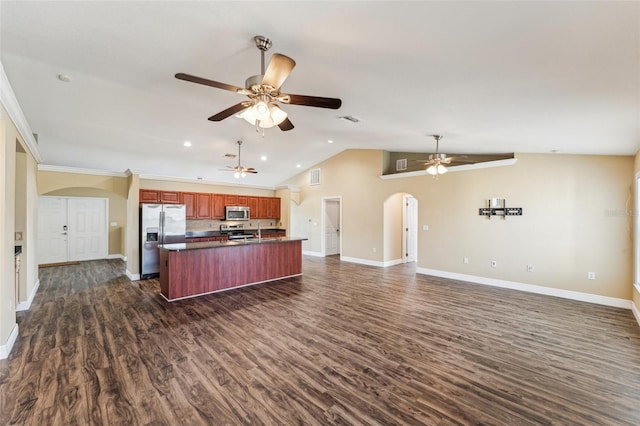 kitchen featuring vaulted ceiling, dark hardwood / wood-style floors, an island with sink, ceiling fan, and stainless steel appliances