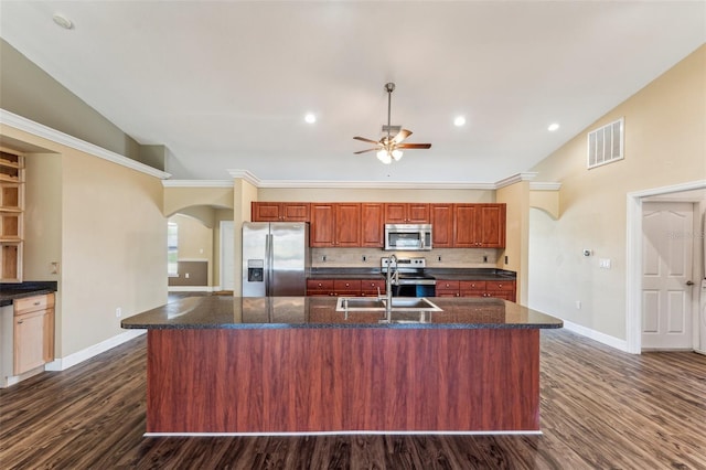 kitchen with sink, a center island with sink, dark stone countertops, dark hardwood / wood-style floors, and stainless steel appliances