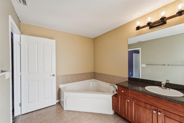 bathroom with vanity, tile patterned flooring, and a washtub