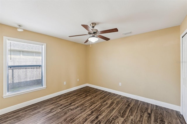 spare room with dark hardwood / wood-style floors and ceiling fan