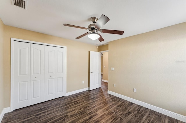 unfurnished bedroom with ceiling fan, dark hardwood / wood-style floors, and a closet