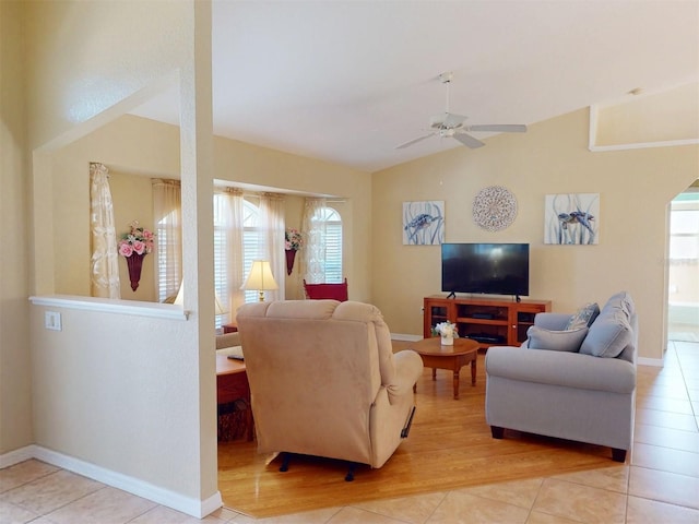 living room featuring ceiling fan, lofted ceiling, and light tile patterned floors