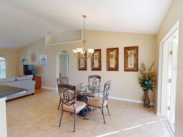 dining space with light tile patterned flooring, a chandelier, and vaulted ceiling