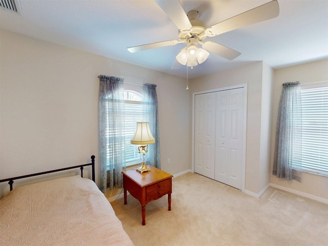 carpeted bedroom featuring a closet and ceiling fan