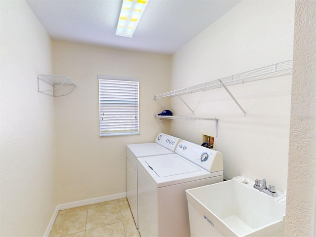 laundry area with separate washer and dryer, sink, and light tile patterned floors