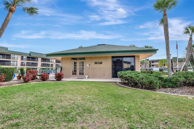 back of property with a lawn and french doors