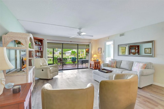 living room with light wood-type flooring and ceiling fan