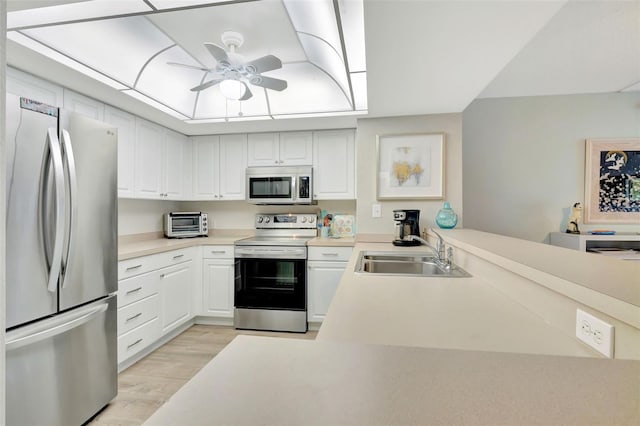 kitchen featuring appliances with stainless steel finishes, ceiling fan, light hardwood / wood-style floors, sink, and white cabinetry