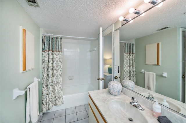 bathroom with vanity, shower / bathtub combination with curtain, tile patterned flooring, and a textured ceiling