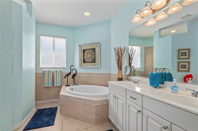 bathroom with vanity, tiled tub, tile patterned flooring, and a healthy amount of sunlight