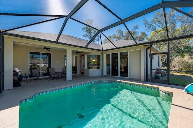 view of swimming pool featuring ceiling fan, a lanai, and a patio area