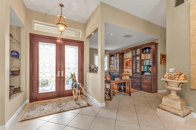 foyer featuring french doors and light tile patterned floors