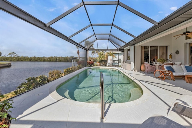 view of pool with a lanai, a patio, ceiling fan, and a water view