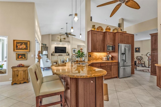 kitchen with appliances with stainless steel finishes, pendant lighting, sink, light tile patterned floors, and kitchen peninsula