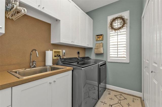 laundry area featuring sink, cabinets, and washer and dryer