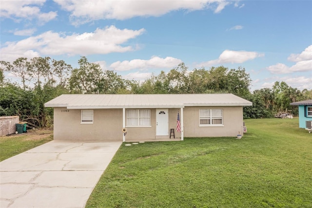 single story home featuring cooling unit and a front lawn