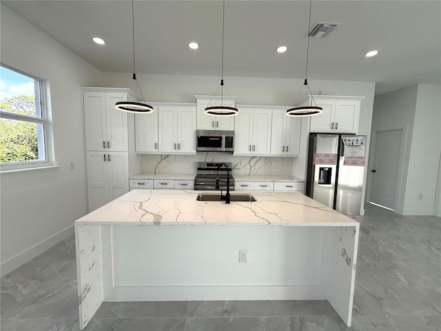 kitchen featuring sink, stainless steel appliances, light stone counters, white cabinets, and decorative light fixtures