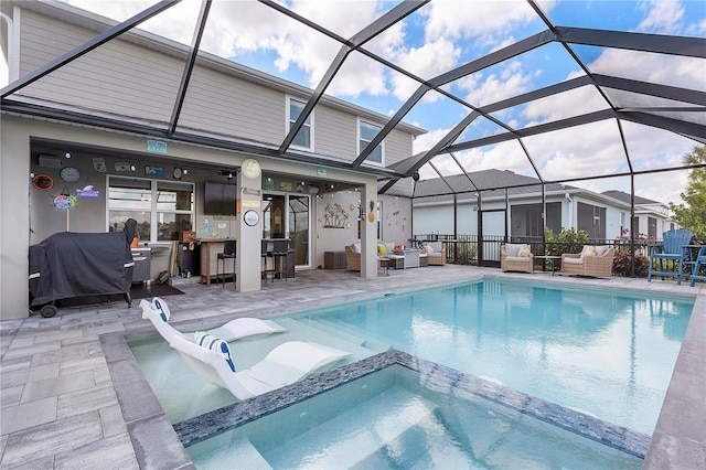 view of pool with a bar, an in ground hot tub, a lanai, an outdoor living space, and a patio area