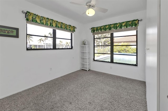 empty room featuring ceiling fan, plenty of natural light, and carpet flooring