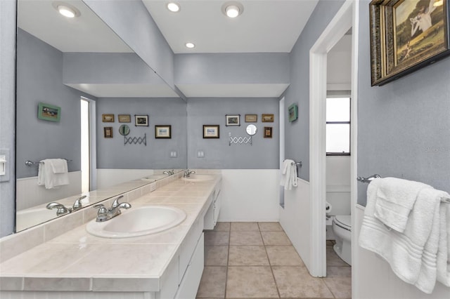 bathroom featuring vanity, tile patterned floors, and toilet