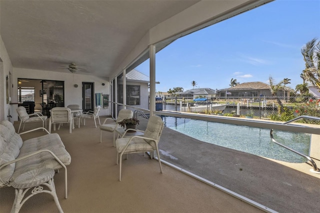 balcony featuring a water view and ceiling fan