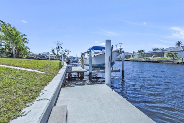 dock area with a lawn and a water view