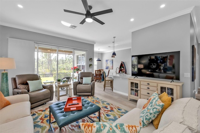 living room featuring light hardwood / wood-style floors, ceiling fan, and ornamental molding