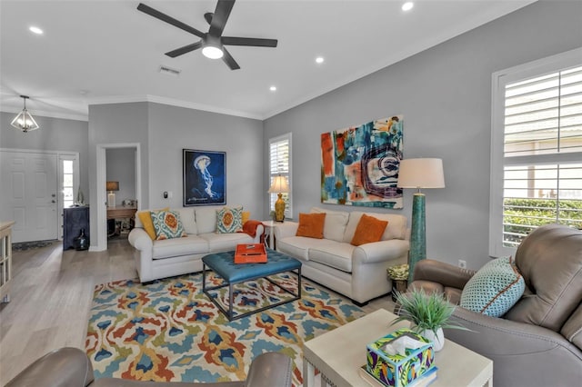 living room with light hardwood / wood-style floors, plenty of natural light, crown molding, and ceiling fan