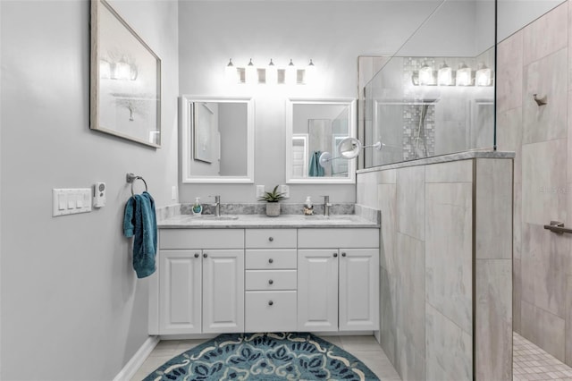 bathroom with tile patterned flooring, vanity, and a tile shower